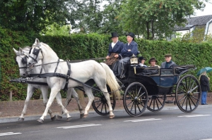 De 4-persoons landauer getrokken door 2 witte paarden
