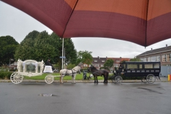 De witte rouwkoets met schimmels en een verlengde volgkoets met friese paarden geschikt voor 16 personen.